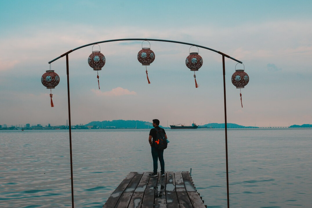 Fisherman standing on a wooden dock at a coastal port